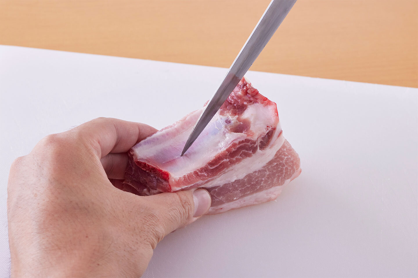 スペアリブは骨に張り付いている薄皮に、包丁で切り目を入れる（こうすると、骨と肉がはがれやすくなる）。熱湯をかけてから、水で洗って水気をきる。大根は皮をむいて大きめの乱切りにする。にんにくはつぶし、しょうがは薄切りにする。