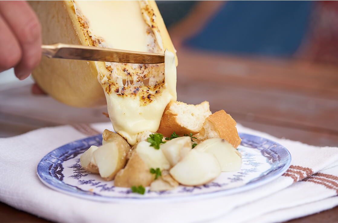 チーズの断面を直火で炙り、トロトロに溶けたところでお好みの食材（今回はボイルドポテト）にブッかけて食べるという逸品だ。